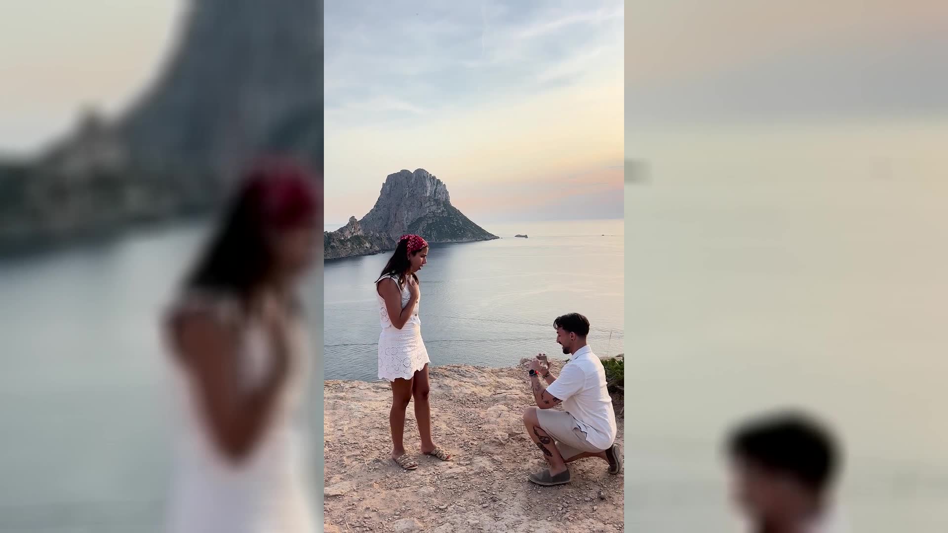 Joana and Cristian embracing at golden hour at Es Vedrà, Ibiza, where they got engaged. The island of Es Vedrà rises from the sea behind them.